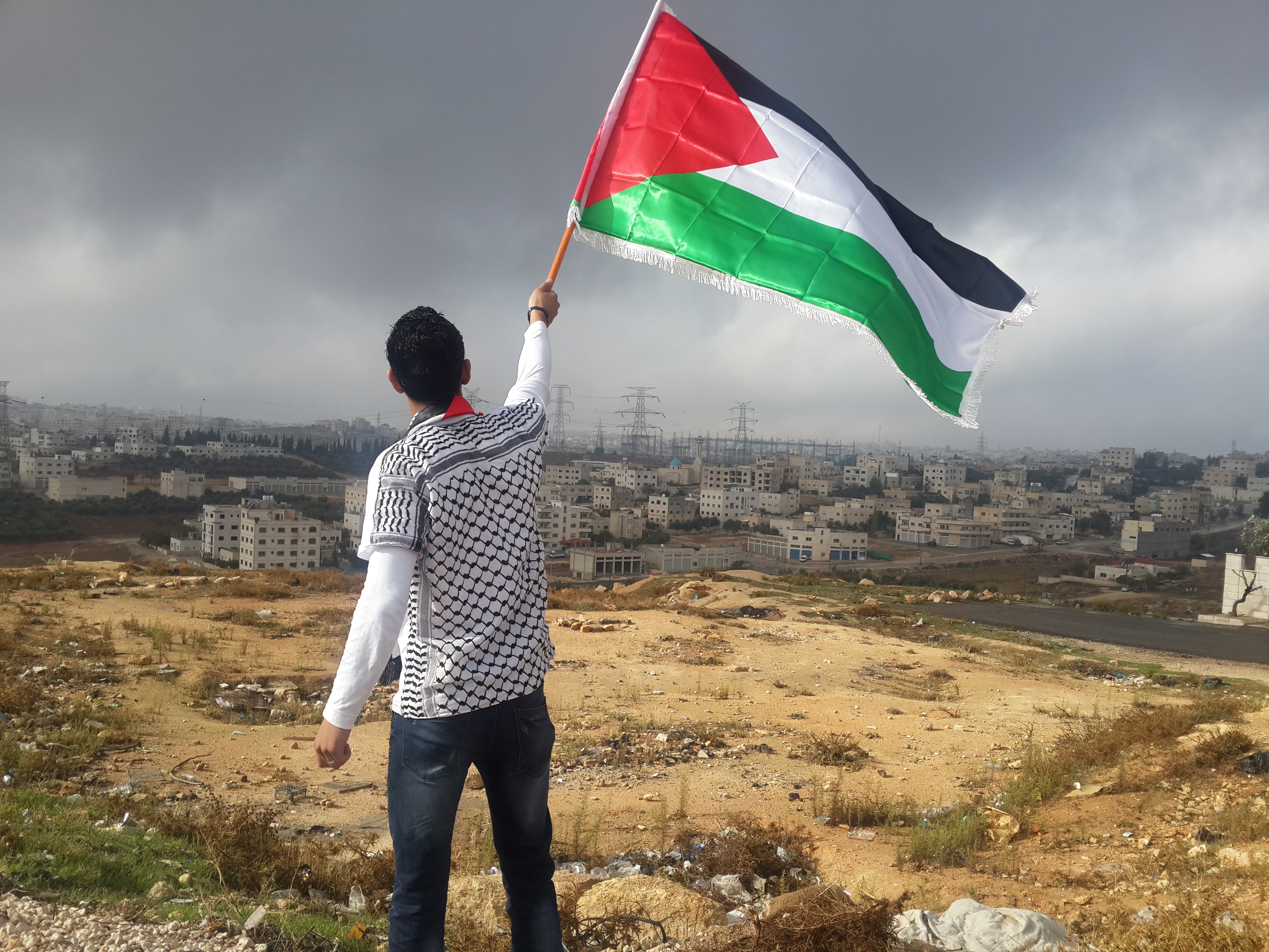 Man waving Palestine flag, showing the importance of international solidarity.